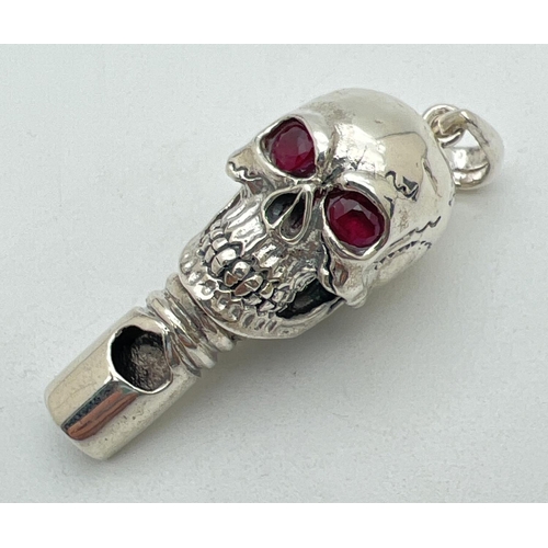 1121 - A modern 925 silver whistle pendant in the form of a skull with ruby set eyes & hanging bale. Marked... 