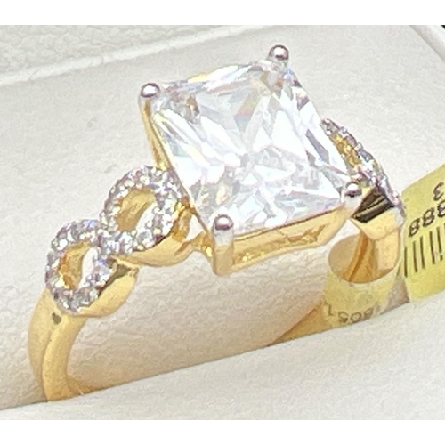 1030 - A 14kt gold plated cocktail ring set with Swarovski crystals. Central emerald cut clear stone with f... 