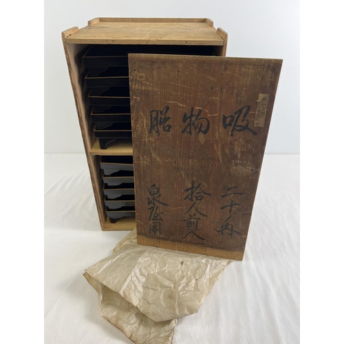 1216 - A collection of 10 Japanese black lacquer footed stands/trays in a wooden box with Chinese lettering... 