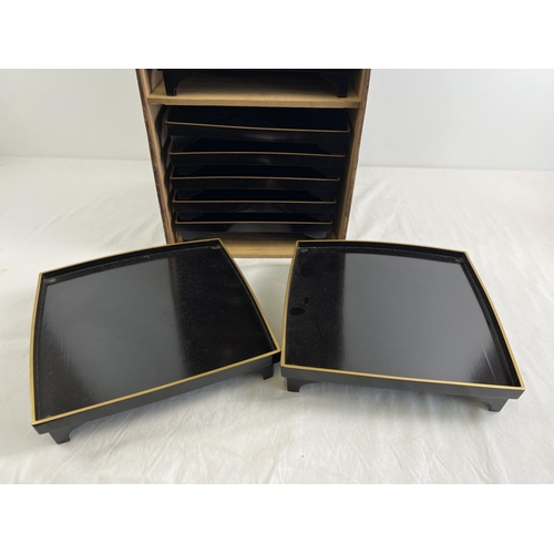 1216 - A collection of 10 Japanese black lacquer footed stands/trays in a wooden box with Chinese lettering... 