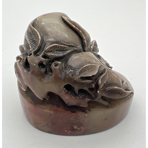 1221 - A small Chinese soapstone oval shaped seal with carved detail of fruits & leaves. Approx. 4cm tall.