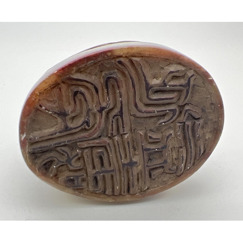 1221 - A small Chinese soapstone oval shaped seal with carved detail of fruits & leaves. Approx. 4cm tall.