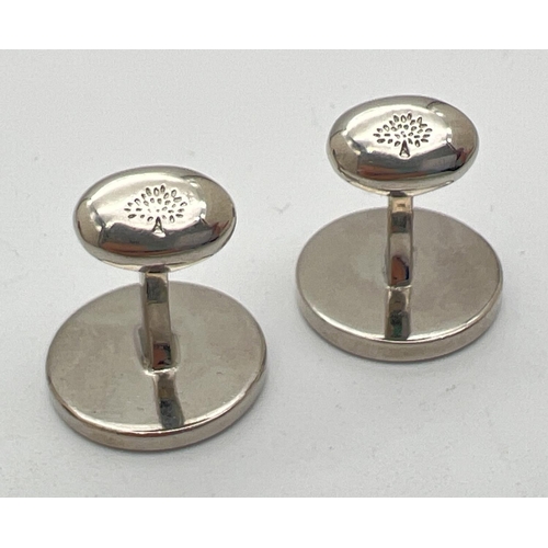 1040 - A pair of silver tone circular cufflinks by Mulberry. Mulberry name and tree logo to fronts with hin... 