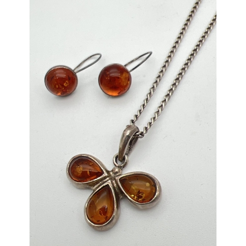 1044 - A flower design silver and amber pendant on a 20 inch curb chain with spring ring clasp. Together wi... 