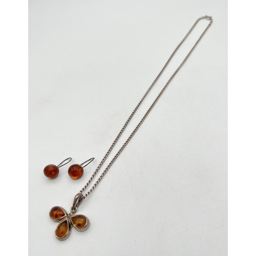 1044 - A flower design silver and amber pendant on a 20 inch curb chain with spring ring clasp. Together wi... 