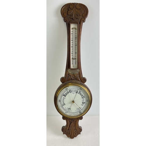 1158 - A 1920's oak cased banjo barometer with integral thermometer. Carved detail to case and engraved pre... 