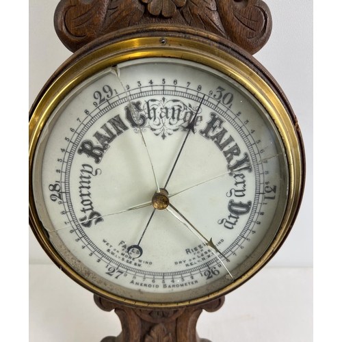 1158 - A 1920's oak cased banjo barometer with integral thermometer. Carved detail to case and engraved pre... 