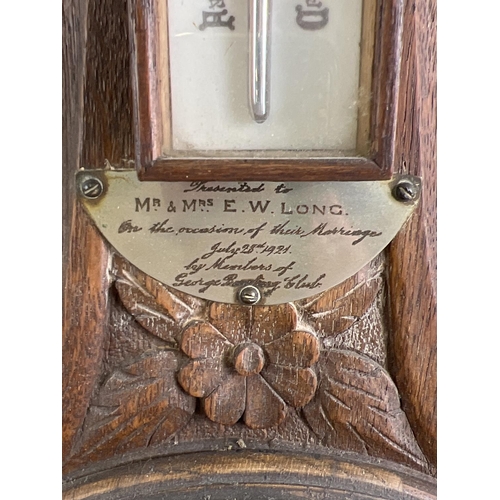 1158 - A 1920's oak cased banjo barometer with integral thermometer. Carved detail to case and engraved pre... 