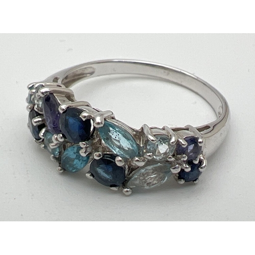 1050 - A 9ct white gold dress ring set with marquise and round cut, blue topaz, aquamarine and iolite stone... 