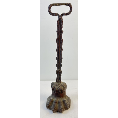 1150 - A Victorian long handled metal door stop in the shape of a lions paw. Approx. 38.5cm tall.