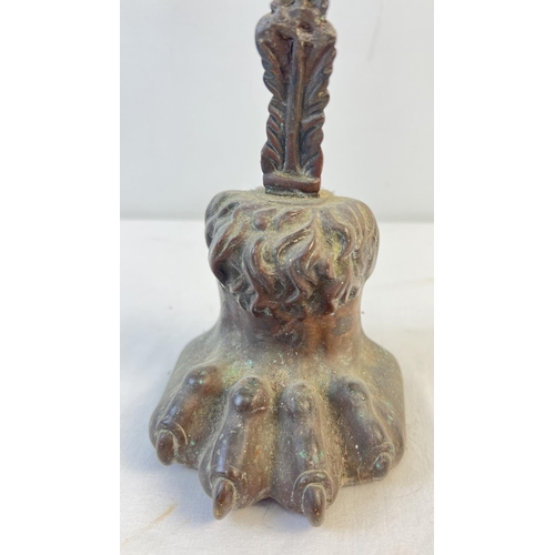 1150 - A Victorian long handled metal door stop in the shape of a lions paw. Approx. 38.5cm tall.