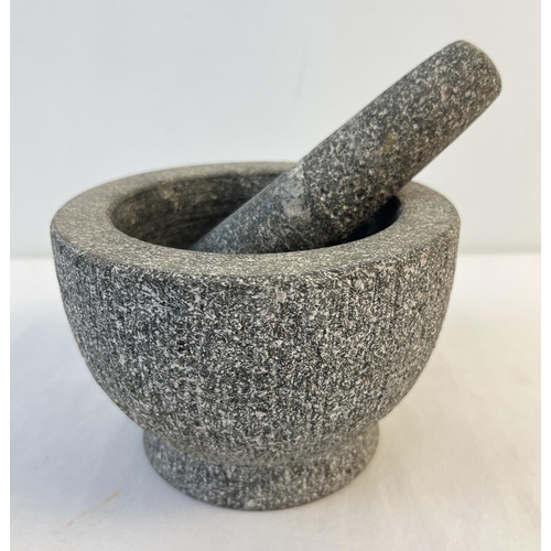 1295 - A heavy granite circular pestle and mortar. Approx. 16cm diameter x 11.5cm tall.