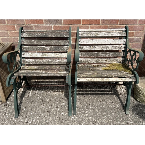 1488 - A pair of slatted wood garden seats with cast iron ends, painted green, with scroll detail. Each app... 