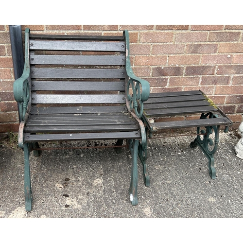 1512 - A wooden slatted garden seat and matching footstool/side table, with cast iron ends. Painted green w... 