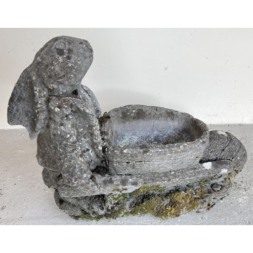 1522 - A weathered concrete garden planter modelled as a rabbit pushing a wheel barrow. Approx. 40cm tall x... 