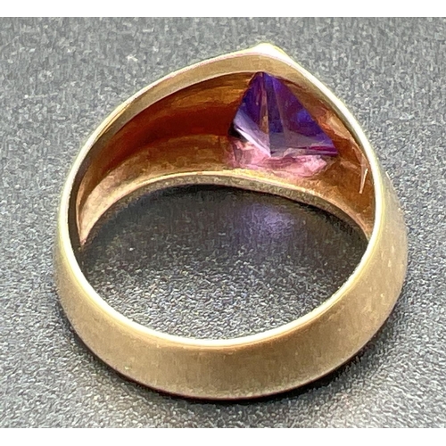 1059 - A modern design 10k gold chunky ring set with triangular shaped purple sapphire stone. Stamped '10k ... 