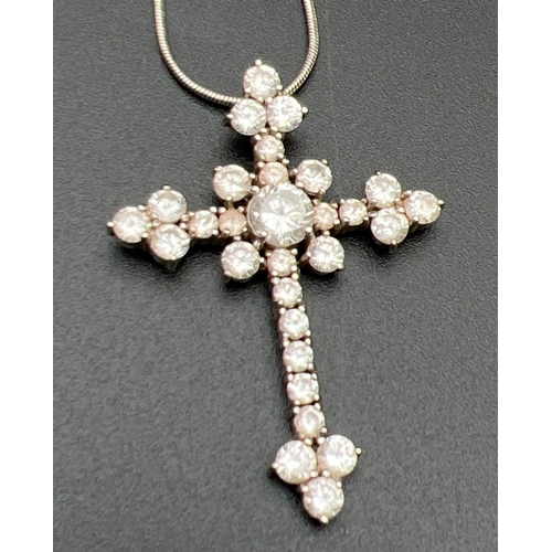 1064 - A large silver and cubic zirconia set cross shaped pendant on a 16