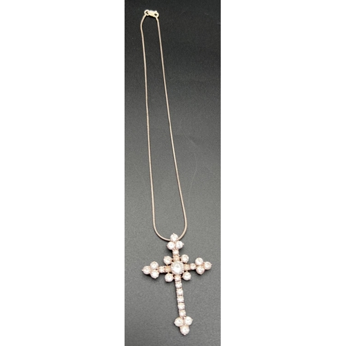 1064 - A large silver and cubic zirconia set cross shaped pendant on a 16