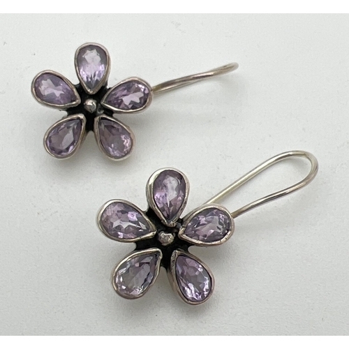 205 - A pair of silver and amethyst flower shaped drop style earrings with hooked posts. Each earring set ... 