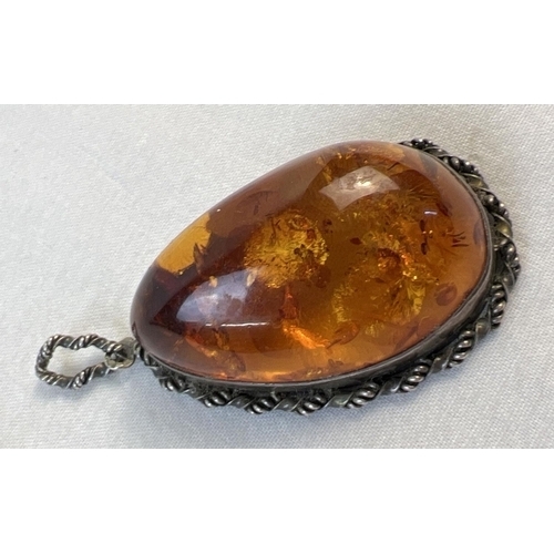 1056 - A large cognac amber pendant with a silver rope design mount and bale. Silver marks to bale. Pendant... 