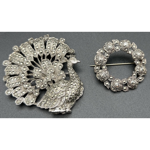 1068 - 2 vintage brooches both set with marcasite stones. A silver circular rose detail brooch marked 