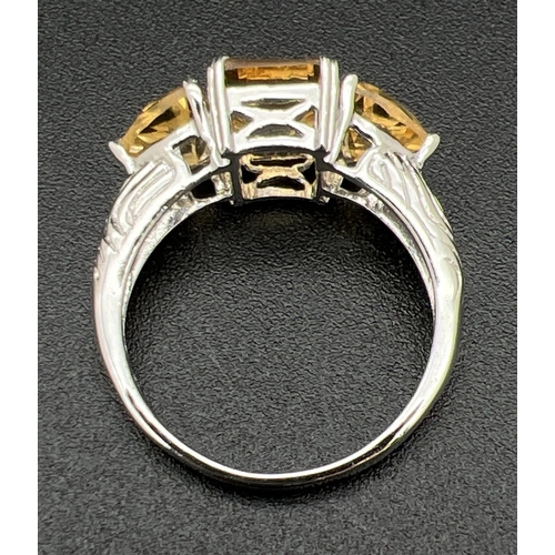 1069 - A silver and citrine 3 stone cocktail ring, set with square cut central stone flanked by 2 trilliant... 