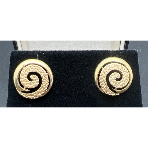 1070 - A pair of 9ct gold vintage spiral design stud earrings in both plain and hammered effect finish. Stu... 