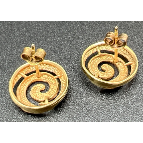 1070 - A pair of 9ct gold vintage spiral design stud earrings in both plain and hammered effect finish. Stu... 