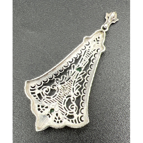 1072 - A large 10k white gold filigree style drop pendant, set with a round cut diamond & 2 diamond cut gre... 