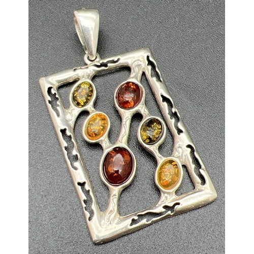 1100 - A large modern design square shaped pendant set with honey, green and cognac amber cabochons. With c... 