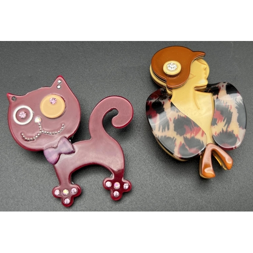 1103 - 2 lea Stein style Lucite brooches. A maroon coloured cat set with iridescent stones together with a ... 