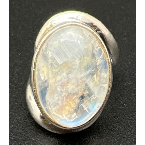 1105 - A modern design silver dress ring with twist style mount  set with a large moonstone cabochon. Silve... 