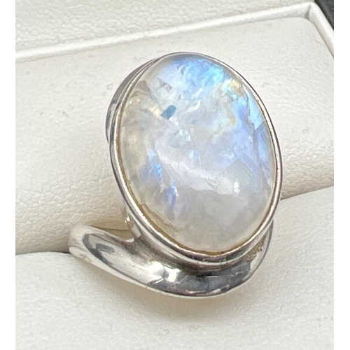 1105 - A modern design silver dress ring with twist style mount  set with a large moonstone cabochon. Silve... 