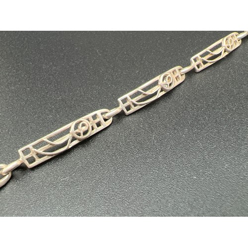 1152 - A silver 7 panel pierced work Rennie Mackintosh style bracelet with rose design. Approx. 8 inches lo... 