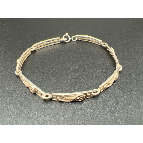 1152 - A silver 7 panel pierced work Rennie Mackintosh style bracelet with rose design. Approx. 8 inches lo... 