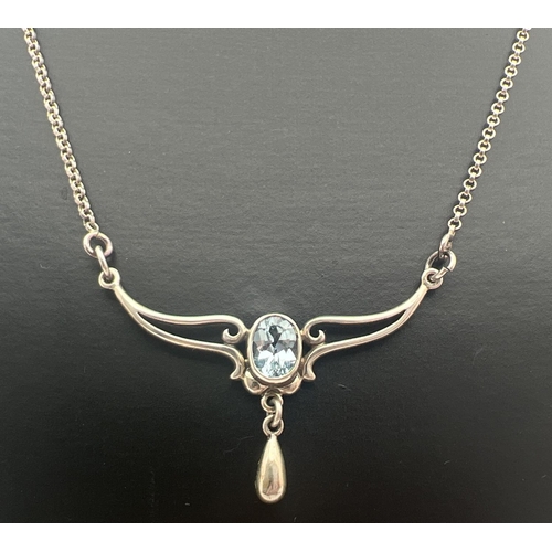 1005 - An Art Nouveau design silver fixed pendant necklace set with an oval cut blue topaz and a small silv... 
