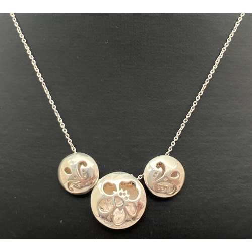 1011 - A silver 3 circular sliding bead necklace with floral pierced work designs to each. 16