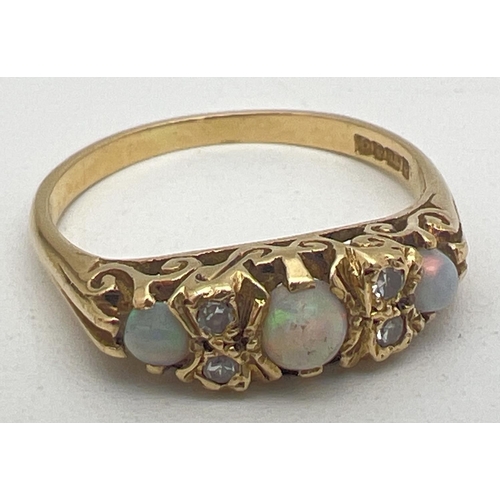 1001 - A Victorian style 18ct gold opal and diamond gypsy dress ring with pierced scroll design mount. Ring... 