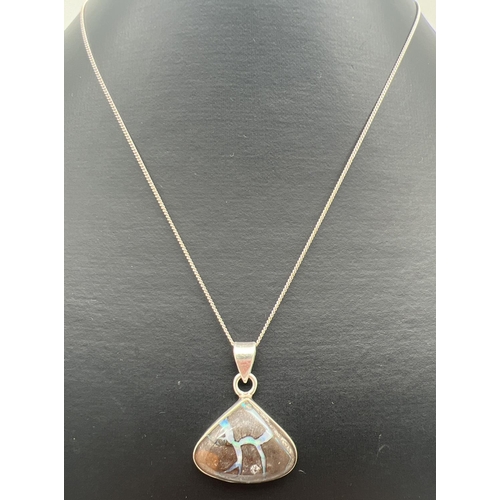 1016 - A modern design silver triangular pendant set with a boulder opal, on a 20