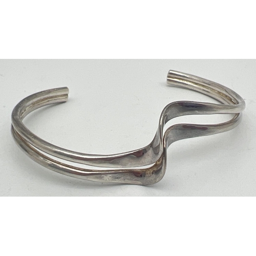 1019 - A silver modern design double wave style cuff bangle. Silver marks to inside. Total weight approx. 1... 