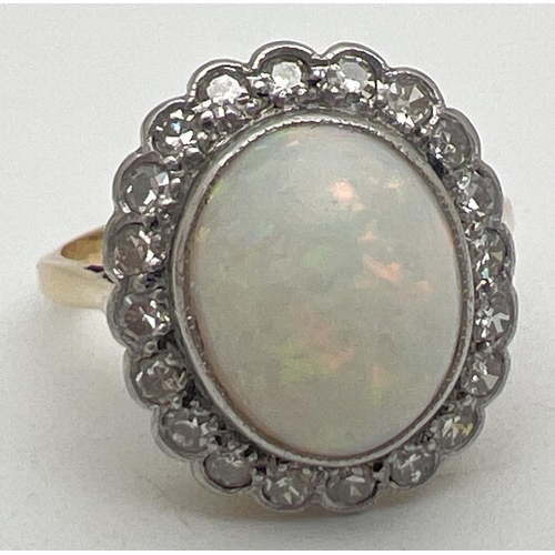 1023 - An opal and diamond 18ct gold dress ring. Central oval cut opal surrounded by 20 round cut small 0.0...