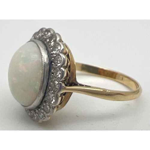 1023 - An opal and diamond 18ct gold dress ring. Central oval cut opal surrounded by 20 round cut small 0.0... 