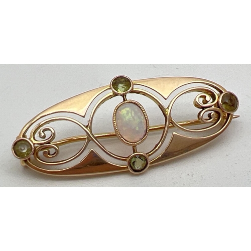 A Murrle Bennet & Co Art Nouveau 15ct gold brooch set with central oval cut opal and 4 small round cut peridots. Stamped 15ct to reverse and marked with makers mark. Brooch approx. 3.6cm long.