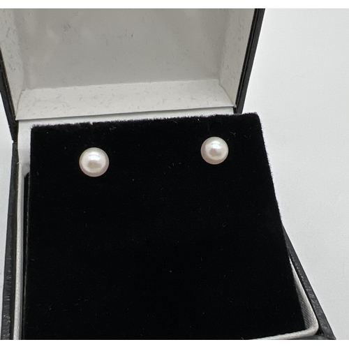 1061 - A pair of 9ct gold pearl stud earrings, with butterfly backs. Marks 9ct to backs. Total weight appro... 