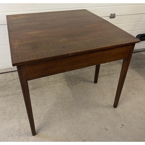 1432 - A vintage dark oak fold over tea table with square shaped taped legs and gate leg support. Approx. 7... 