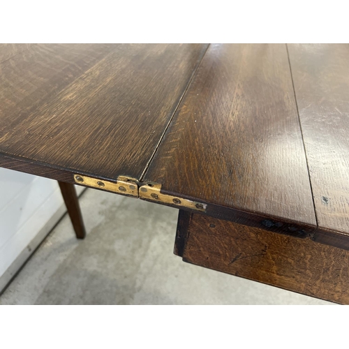 1432 - A vintage dark oak fold over tea table with square shaped taped legs and gate leg support. Approx. 7... 