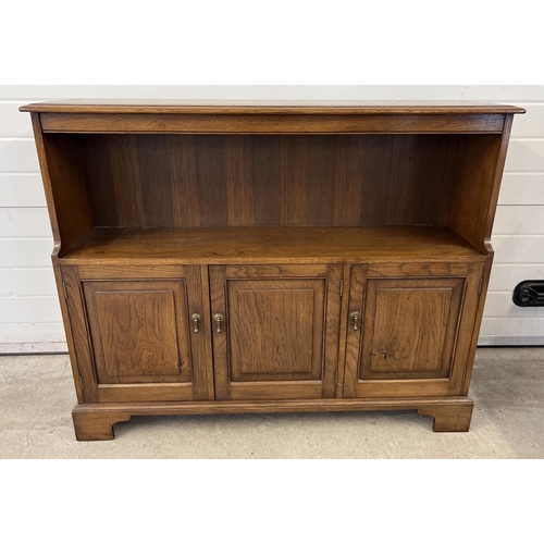 1435 - A vintage Simon Simpson, Norwich, solid dark oak bookcase with 3 door cupboard underside. Double and... 