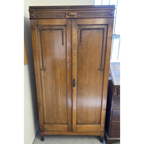 1442 - A vintage 1930's oak gentleman's wardrobe with beaded and carved detail to front. Interior has pull-... 