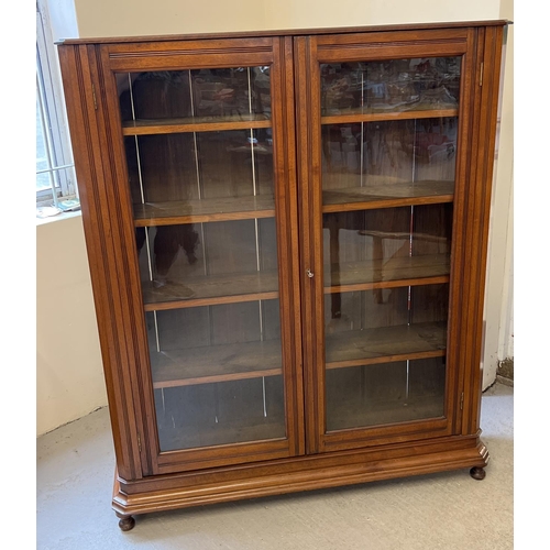 1443 - An Art Deco dark oak 2 door, glass fronted bookcase with channelled detail, complete with key. 4 sol... 