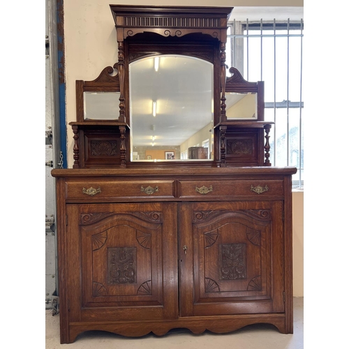 1445 - An Edwardian dark oak mirror backed side board with decorative carved columns and panelled detail. B... 